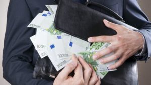 Businessman with money in studio on a gray background. Corruption concept
